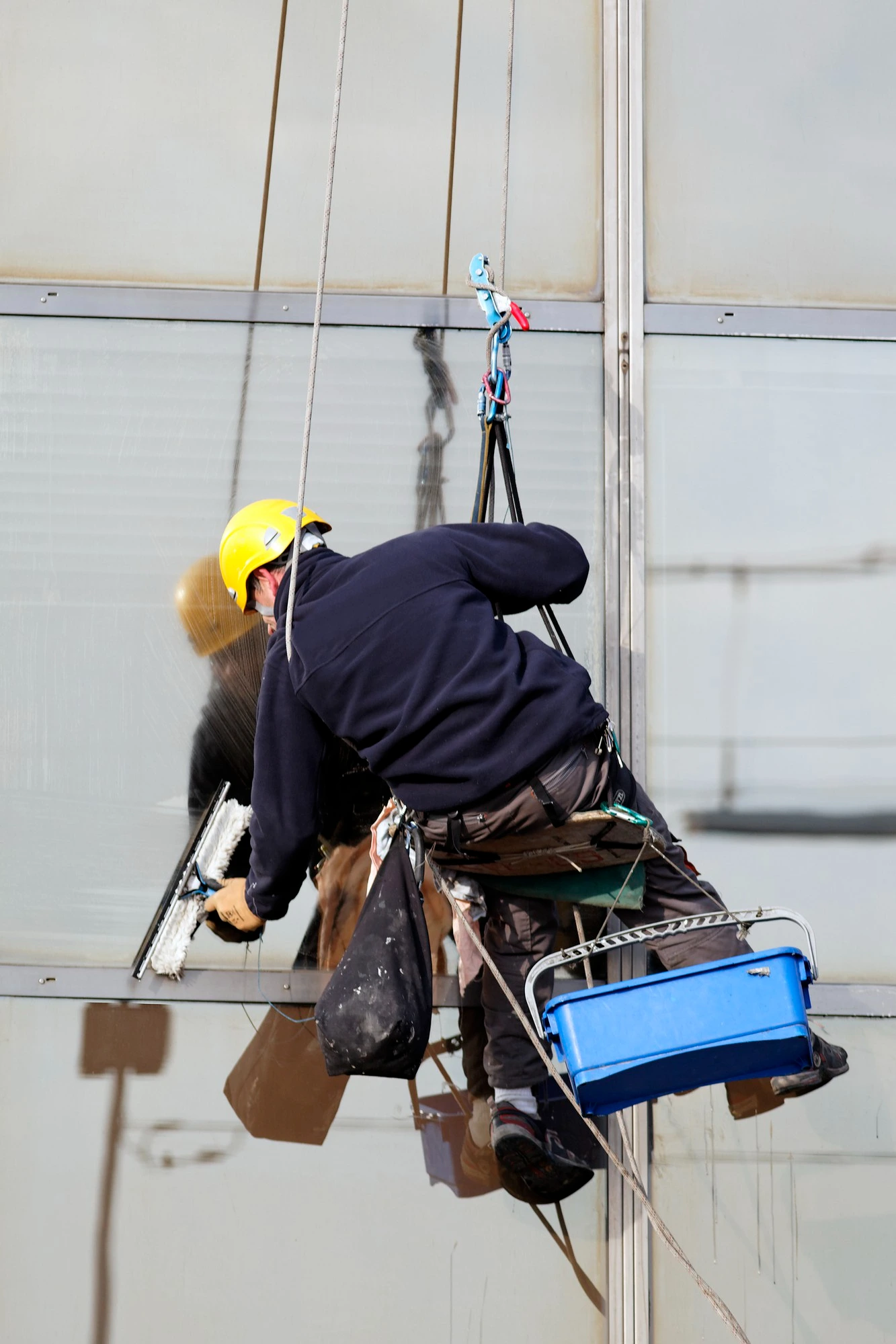 hombre limpiando colgado ventana