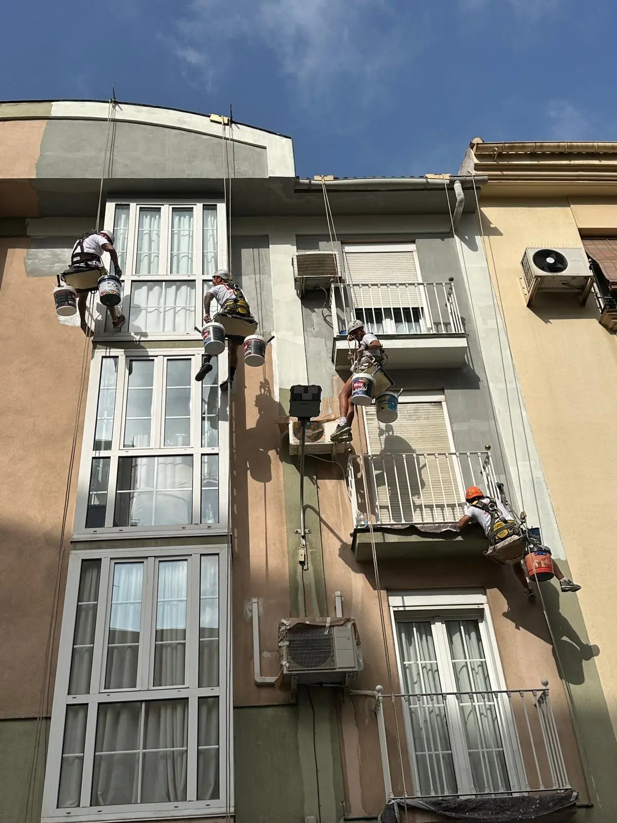 personas colgadas pintando